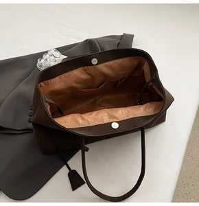 Dettagli interni della borsa tote marrone con fodera stampata e chiusura magnetica