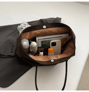 Vista interna che mostra la grande capacità della borsa tote marrone con tablet