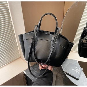 Detail of black pebbled leather tote bag with sturdy handles and fine stitching