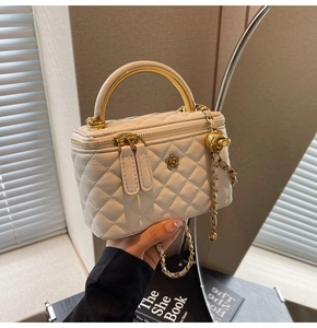 Detailansicht der weißen gesteppten Mini-Tasche mit goldenem Kamelien-Logo und Griff