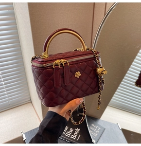 Nahaufnahme der burgunderroten Stepptasche aus Leder mit goldenem Blumendekor