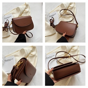 Detail view of a caramel leather crossbody bag with vintage gold hardware and adjustable strap