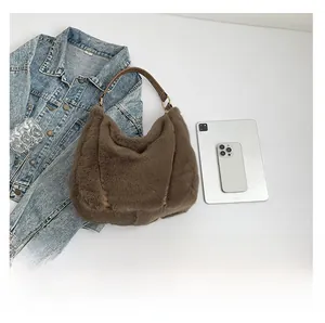 Flat lay of brown plush hobo bag with leather straps and modern styling items