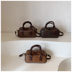 Detailed view of three vintage-style mini Boston bags with shiny PU leather and gold hardware