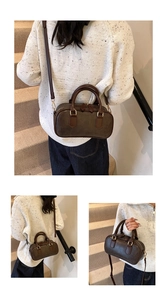 Detailed view of the dark brown vintage leather handbag with golden metal hardware