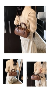 Close-up of brown vintage Boston bag with adjustable strap and textured PU leather