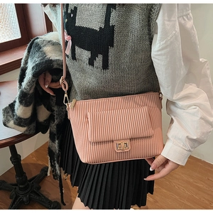 Gros plan du sac en velours côtelé rose clair avec fermoir doré et texture détaillée