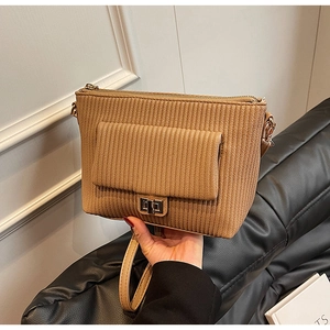 Detail showing brown corduroy texture and metal swivel lock on the flap of the large bag