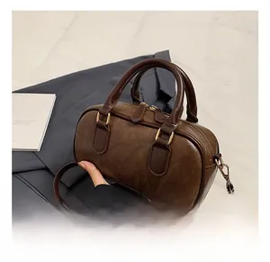 Detail showing high-quality dark brown matte texture and gold hardware of the Boston bag