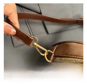 Macro detail of high-quality gold metal hook and buckle on a vintage brown leather bag