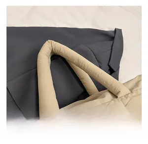 Detail of soft khaki quilted tote bag with padded handles and textured fabric finish