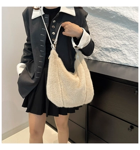 Detail of cream plush faux fur shoulder bag with white leather strap and gold hardware
