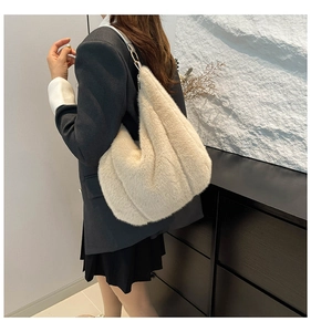 Detail view of cream plush tote bag with slim leather straps on female model