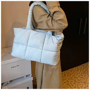 Macro-opname van de hemelblauwe gewatteerde shopper met handvaten voor de winter