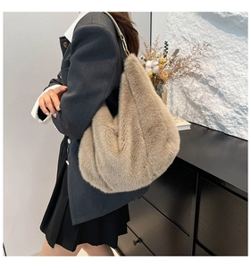 Detail view of large faux fur tote bag in beige plush material worn by a model