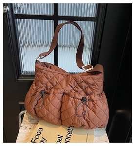 Detail der braunen Stepptasche mit zwei Kordelzugtaschen und weicher Puffer-Textur