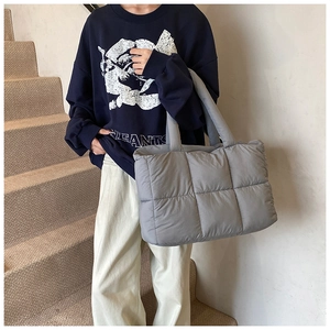 Close-up of grey quilted puffer tote bag in lightweight nylon fabric with padded handles