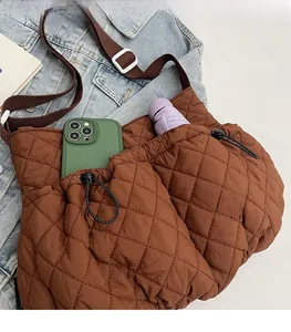 Detail der braunen Stepptasche mit zwei Kordelzug-Fronttaschen für Handy und Regenschirm