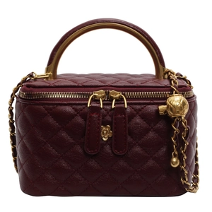 Quilted burgundy leather handbag with gold handle and camellia chain strap detail