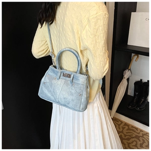 Side view of a vintage light blue textured crossbody bag styled with a modern casual outfit