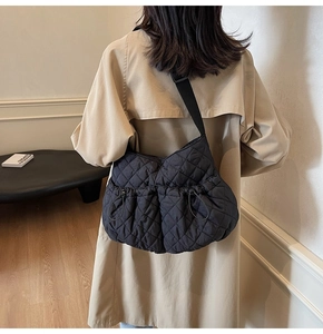 Close-up of black quilted dumpling bag with adjustable strap and side drawstring detail