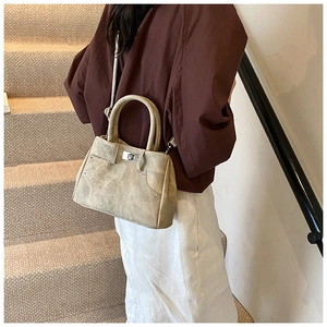 Detail of vintage khaki handbag showing texture, turn-lock closure and rivet accents