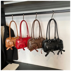 Detail of four colorful Boston shoulder bags with bow ties and front zippers