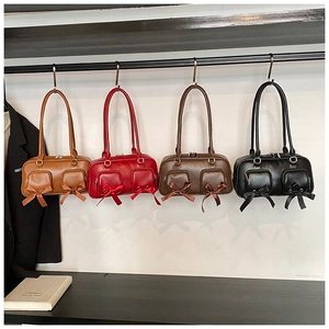 Detail of four retro leather underarm bags with ribbon bows in brown, red, coffee, and black