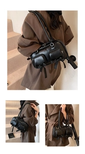 Detail showing matte black bow accent and dual zipper pockets on the bowling shoulder bag