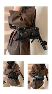 Detail of a black leather shoulder bag with silver zippers and ribbon bow accents