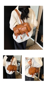 Detail of brown leather shoulder bag featuring ribbon bows and functional zipper pockets