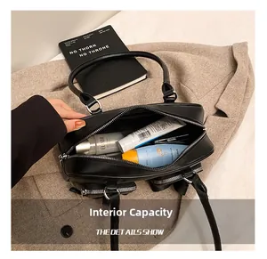 Internal capacity of minimalist black leather underarm bag showing toiletries and storage