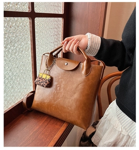 Detail van vintage bruine leren tas met zilveren gesp en klein tasje met luipaardprint