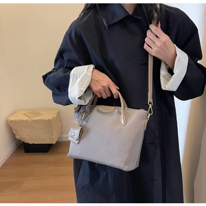 Detail view of large nylon tote bag with leather straps and detachable shoulder strap