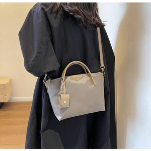 Detail of taupe oxford tote bag featuring CLEART K branding and mini accessory pouch