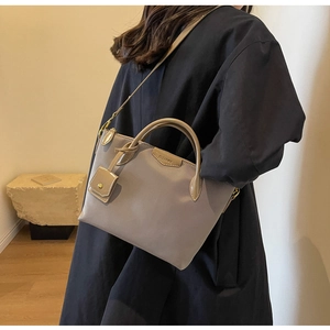 Taupe oxford tote bag with leather handles and Clear SK logo detail shown on model