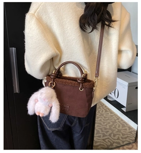 Détail du sac seau d'hiver en peluche avec breloque lapin blanc et bords doux