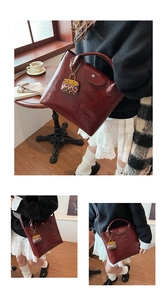 Detail van donkerrode draagtas met luipaard hanger in hand- en crossbody-stijlen getoond