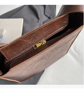 Detail of vintage gold-tone zipper and textured faux leather on dark brown tote bag