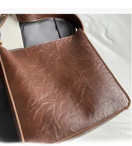 Close-up of vintage brown tote bag showing soft pleated oil wax leather texture