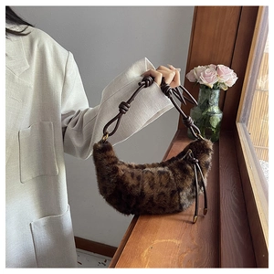 Detailed view of plush leopard print hobo bag with leather knot strap and zipper