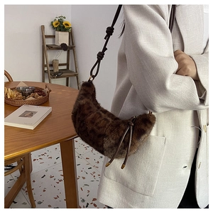 Détail du sac croissant en peluche léopard avec bandoulière en cuir et gland en métal