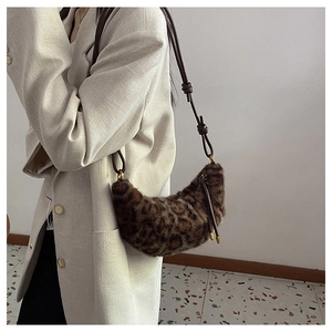 Vue détaillée du sac croissant en fausse fourrure léopard porté avec un blazer