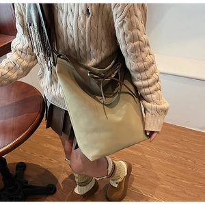 Détail du sac fourre-tout vintage vert olive avec lanières en cuir et nœud décoratif