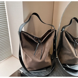 Detailed view of the dark brown matte tote bag with soft texture and slim bow tie detail