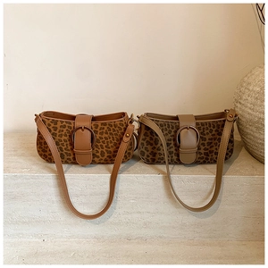 Detail view of leopard print bucket bags in warm brown and cool taupe with buckle accents