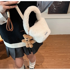 Gros plan détaillé du sac à main en peluche blanche douce avec pendentif ours et étiquette
