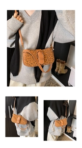 Detail of leopard print shoulder bag with brown leather buckle and adjustable strap