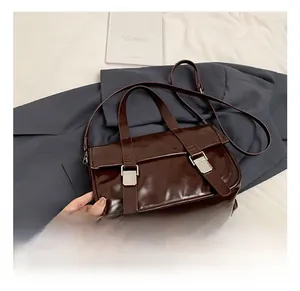 Detail view of retro dark brown oily leather satchel with dual silver buckles and strap
