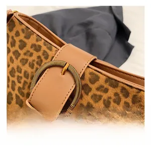 Detailed macro view of vintage gold round buckle on leopard print velvet bucket bag